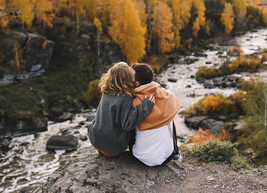 Couple sitting on a rock by the river