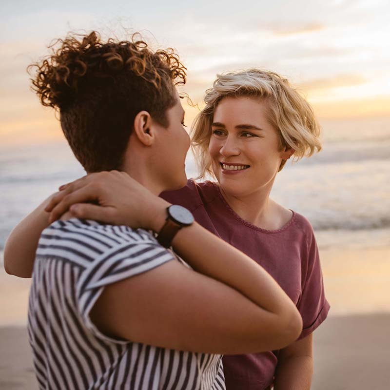 Female couple at the beach at sunset