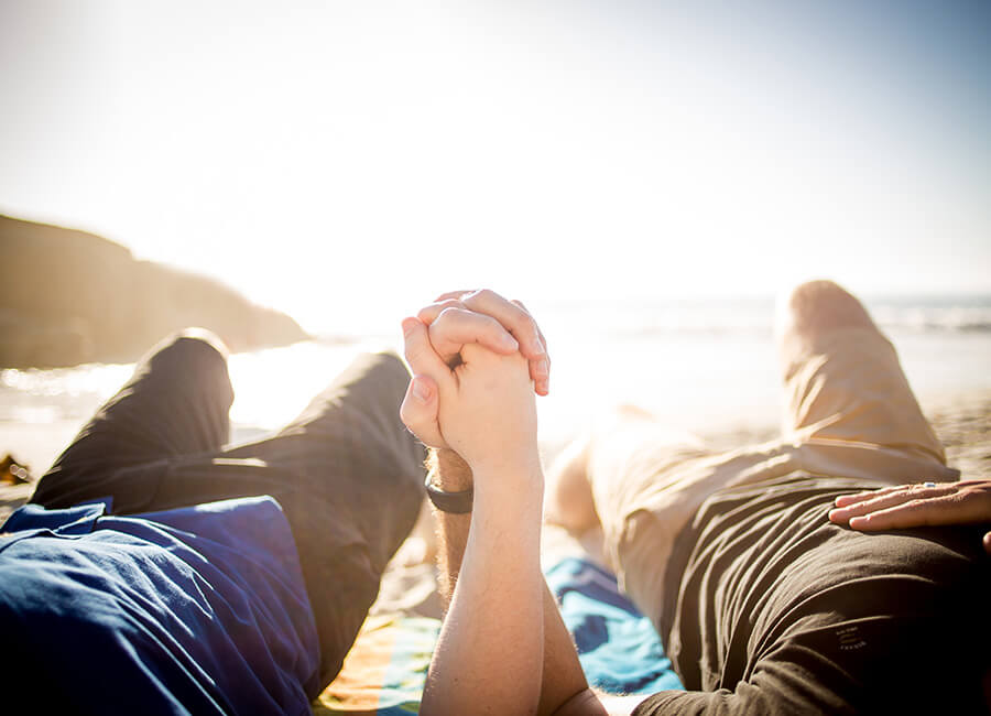 Male couple holding hands at the beach
