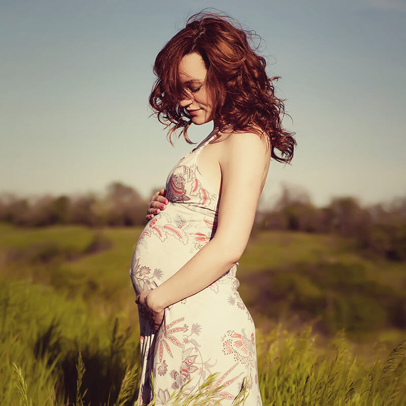 Pregnant woman in a grassy field